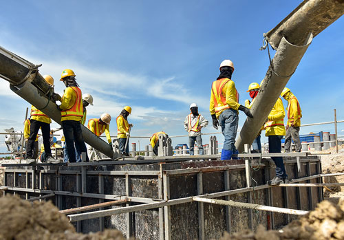 Men pouring concrete in foundation