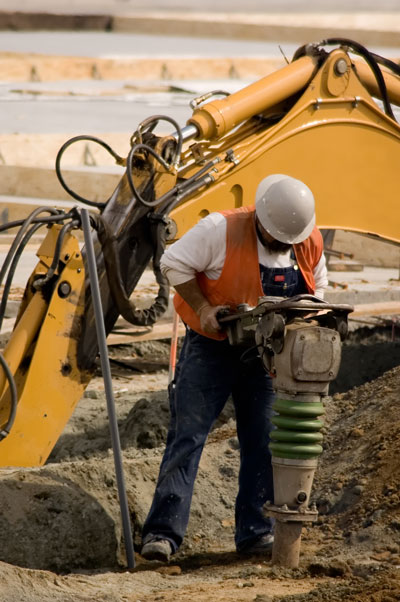 construction worker drilling into ground